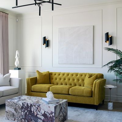 Living room with mustard couch, wall treatment and art work on wall