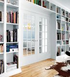 Large white bookcase wall with white moulding and casing around the door and ceiling