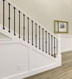 Wood and wrought iron staircase with wall treatment along the side.