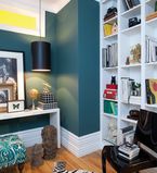 Teal wall with white moulding along the top and bottom of the wall